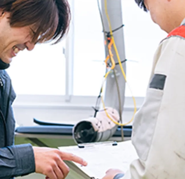 図を見ながら話をする整備士２人